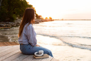 Frau schaut Meer Sonnenuntergang